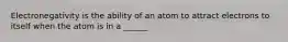 Electronegativity is the ability of an atom to attract electrons to itself when the atom is in a ______