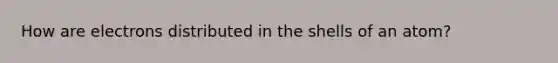 How are electrons distributed in the shells of an atom?