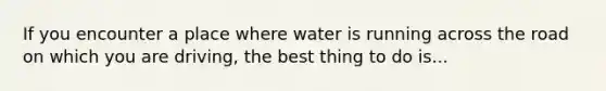 If you encounter a place where water is running across the road on which you are driving, the best thing to do is...