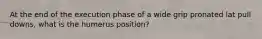 At the end of the execution phase of a wide grip pronated lat pull downs, what is the humerus position?