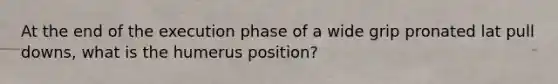 At the end of the execution phase of a wide grip pronated lat pull downs, what is the humerus position?