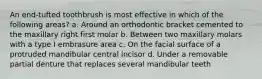 An end-tufted toothbrush is most effective in which of the following areas? a. Around an orthodontic bracket cemented to the maxillary right first molar b. Between two maxillary molars with a type I embrasure area c. On the facial surface of a protruded mandibular central incisor d. Under a removable partial denture that replaces several mandibular teeth