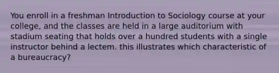 You enroll in a freshman Introduction to Sociology course at your college, and the classes are held in a large auditorium with stadium seating that holds over a hundred students with a single instructor behind a lectem. this illustrates which characteristic of a bureaucracy?