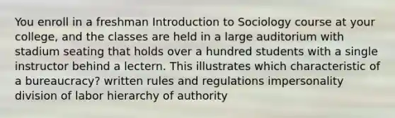 You enroll in a freshman Introduction to Sociology course at your college, and the classes are held in a large auditorium with stadium seating that holds over a hundred students with a single instructor behind a lectern. This illustrates which characteristic of a bureaucracy? written rules and regulations impersonality division of labor hierarchy of authority