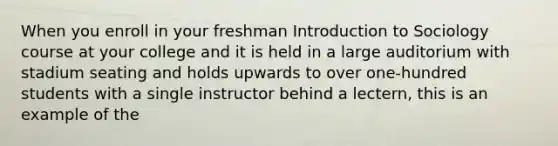 When you enroll in your freshman Introduction to Sociology course at your college and it is held in a large auditorium with stadium seating and holds upwards to over one-hundred students with a single instructor behind a lectern, this is an example of the