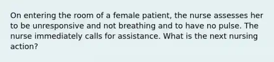 On entering the room of a female patient, the nurse assesses her to be unresponsive and not breathing and to have no pulse. The nurse immediately calls for assistance. What is the next nursing action?