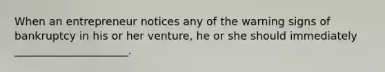 When an entrepreneur notices any of the warning signs of bankruptcy in his or her venture, he or she should immediately _____________________.