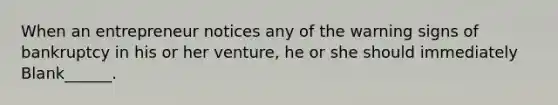 When an entrepreneur notices any of the warning signs of bankruptcy in his or her venture, he or she should immediately Blank______.