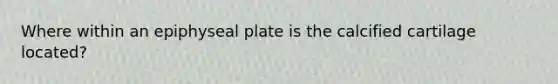 Where within an epiphyseal plate is the calcified cartilage located?