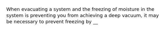 When evacuating a system and the freezing of moisture in the system is preventing you from achieving a deep vacuum, it may be necessary to prevent freezing by __