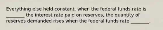 Everything else held​ constant, when the federal funds rate is​ ________ the interest rate paid on​ reserves, the quantity of reserves demanded rises when the federal funds rate​ ________.