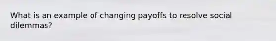 What is an example of changing payoffs to resolve social dilemmas?