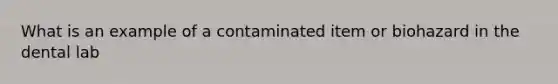 What is an example of a contaminated item or biohazard in the dental lab