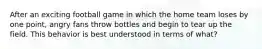 After an exciting football game in which the home team loses by one point, angry fans throw bottles and begin to tear up the field. This behavior is best understood in terms of what?
