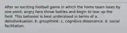 After an exciting football game in which the home team loses by one point, angry fans throw bottles and begin to tear up the field. This behavior is best understood in terms of a. deindividuation. b. groupthink. c. cognitive dissonance. d. social facilitation.