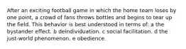 After an exciting football game in which the home team loses by one point, a crowd of fans throws bottles and begins to tear up the field. This behavior is best understood in terms of: a the bystander effect. b deindividuation. c social facilitation. d the just-world phenomenon. e obedience.