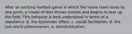 After an exciting football game in which the home team loses by one point, a crowd of fans throws bottles and begins to tear up the field. This behavior is best understood in terms of a. obedience. b. the bystander effect. c. social facilitation. d. the just-world phenomenon. e. deindividuation.