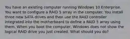 You have an existing computer running Windows 10 Enterprise. You want to configure a RAID 5 array in the computer. You install three new SATA drives and then use the RAID controller integrated into the motherboard to define a RAID 5 array using them. When you boot the computer, Windows does not show the logical RAID drive you just created. What should you do?