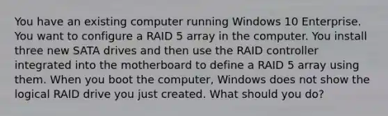 You have an existing computer running Windows 10 Enterprise. You want to configure a RAID 5 array in the computer. You install three new SATA drives and then use the RAID controller integrated into the motherboard to define a RAID 5 array using them. When you boot the computer, Windows does not show the logical RAID drive you just created. What should you do?