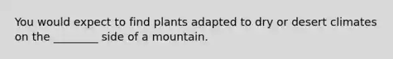 You would expect to find plants adapted to dry or desert climates on the ________ side of a mountain.