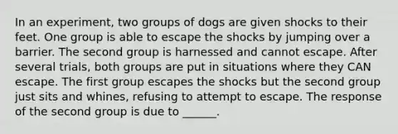 In an experiment, two groups of dogs are given shocks to their feet. One group is able to escape the shocks by jumping over a barrier. The second group is harnessed and cannot escape. After several trials, both groups are put in situations where they CAN escape. The first group escapes the shocks but the second group just sits and whines, refusing to attempt to escape. The response of the second group is due to ______.