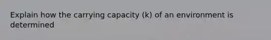 Explain how the carrying capacity (k) of an environment is determined