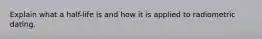 Explain what a half-life is and how it is applied to radiometric dating.