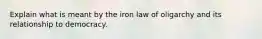 Explain what is meant by the iron law of oligarchy and its relationship to democracy.