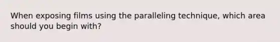 When exposing films using the paralleling technique, which area should you begin with?