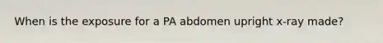 When is the exposure for a PA abdomen upright x-ray made?