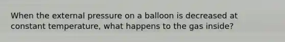 When the external pressure on a balloon is decreased at constant temperature, what happens to the gas inside?