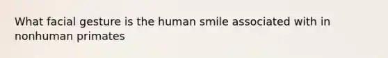 What facial gesture is the human smile associated with in nonhuman primates