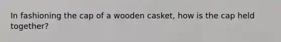 In fashioning the cap of a wooden casket, how is the cap held together?