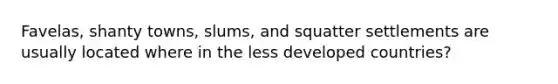 Favelas, shanty towns, slums, and squatter settlements are usually located where in the less developed countries?