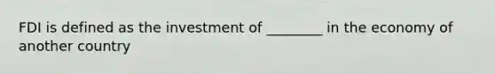 FDI is defined as the investment of ________ in the economy of another country