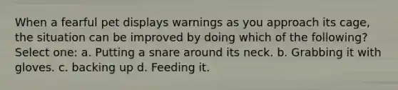 When a fearful pet displays warnings as you approach its cage, the situation can be improved by doing which of the following? Select one: a. Putting a snare around its neck. b. Grabbing it with gloves. c. backing up d. Feeding it.