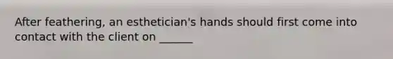 After feathering, an esthetician's hands should first come into contact with the client on ______