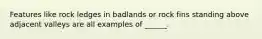 Features like rock ledges in badlands or rock fins standing above adjacent valleys are all examples of ______.