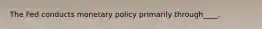 The Fed conducts monetary policy primarily through____.