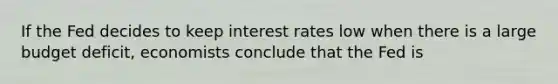 If the Fed decides to keep interest rates low when there is a large budget deficit, economists conclude that the Fed is