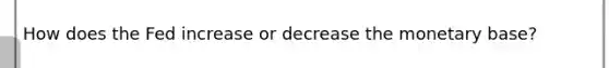 How does the Fed increase or decrease the monetary base?