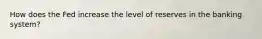 How does the Fed increase the level of reserves in the banking system?