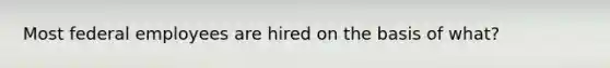 Most federal employees are hired on the basis of what?