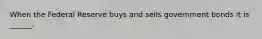 When the Federal Reserve buys and sells government bonds it is ______.