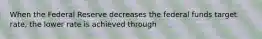 When the Federal Reserve decreases the federal funds target rate, the lower rate is achieved through