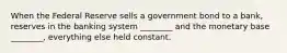 When the Federal Reserve sells a government bond to a bank, reserves in the banking system ________ and the monetary base ________, everything else held constant.