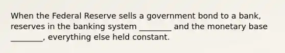 When the Federal Reserve sells a government bond to a bank, reserves in the banking system ________ and the monetary base ________, everything else held constant.