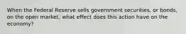 When the Federal Reserve sells government securities, or bonds, on the open market, what effect does this action have on the economy?