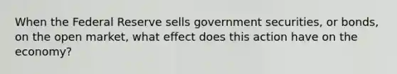 When the Federal Reserve sells government securities, or bonds, on the open market, what effect does this action have on the economy?