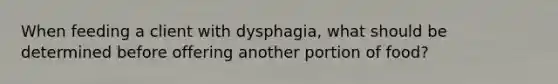 When feeding a client with dysphagia, what should be determined before offering another portion of food?